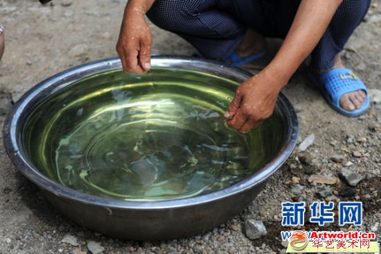 阜新蒙古族自治县那力闪村的一名村民向记者展示刚刚打出的呈绿色的井水（6月24日摄）。新华社记者潘昱龙摄